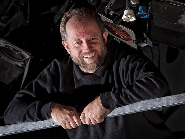 Backstage Hand Among The Stage Lights and Rigging