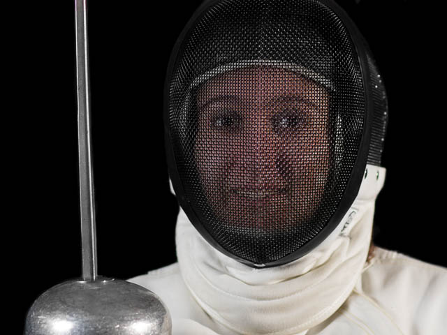 Young Female Fencer Holding Foil and Wearing Fencing Mask