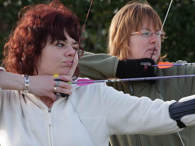Female archery competitors in training