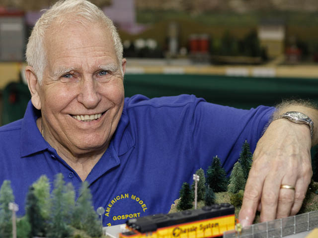 Model Railway Enthusiast Portrait With American Rolling Stock and Layout