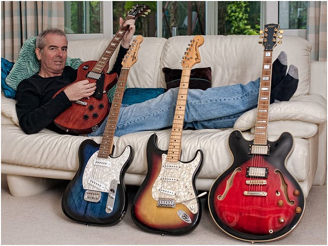 Relaxed Guitarist With Guitar Collection