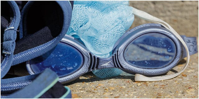 Blue Swimming Goggles With Shower Sponge Drying In The Sun