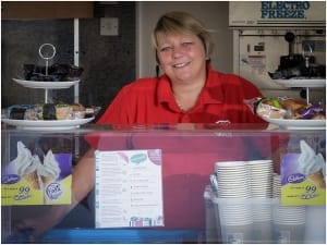 Portrait Of Charity Swimmer At The Counter Of Her Ice Cream Kiosk