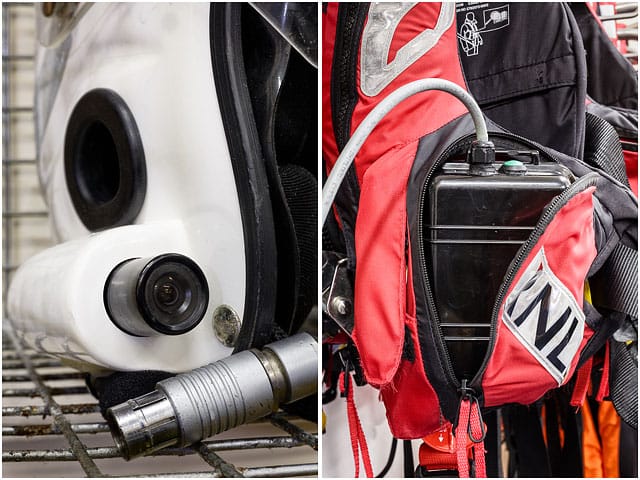 portsmouth-rnli-station-crew-helmet-and-life-jackets White RNLI Helmet Radio and Camera with Battery Pack Hanging in Red Life Preserver
