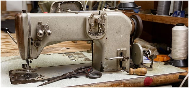 Industrial Sewing Machine With Scissors And Bradawl In Sailmakers Workshop