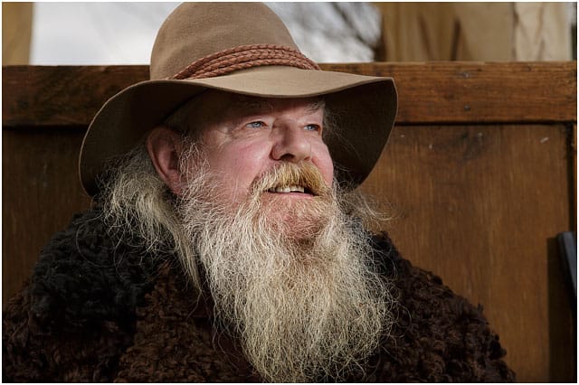 Head And Shoulders Portrait Of A Man Dressed As Wild West Trapper With A White Bushy Beard