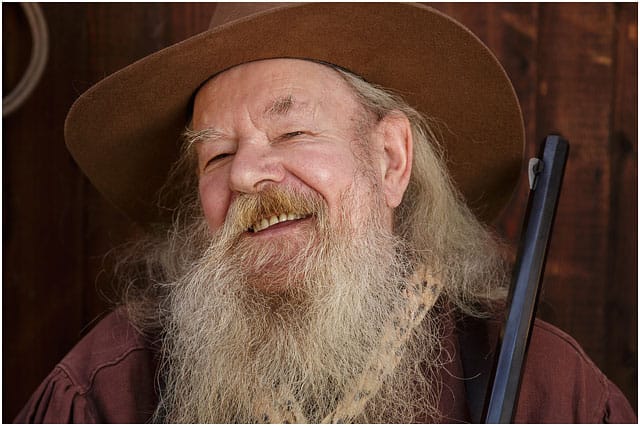 Portrait Of Man Laughing Wearing A Comboy Hat And A Large White Bushy Beard