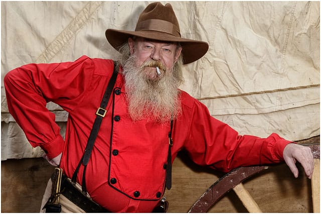 Portrait Of Wild West Cowboy With Red Top And Brown Hat Smoking