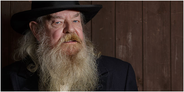 Portrait Of Wild West Preacher With Black Hat And White Bushy Beard Looking Towards Camera