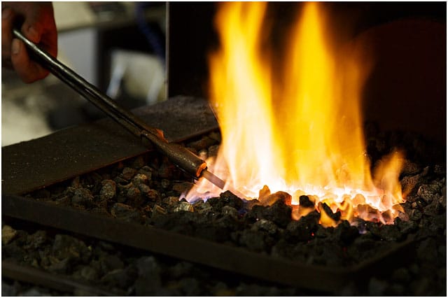 Heating steel rod in blacksmiths forge Heating Steel Rod In Blacksmiths Forge