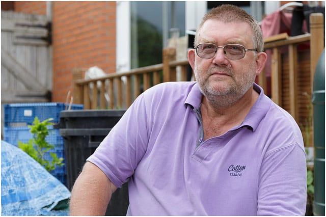 Headshot Portrait Of Man With Glasses And Purple Top In Garden