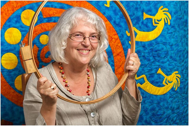 Headshot Portrait Of Textile Artist Framed By Wooden Quilting Hoop