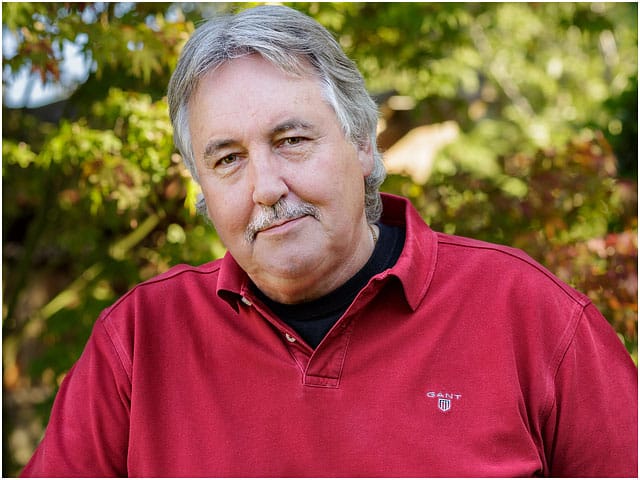 Headshot Portrait Middle Aged Man Red Polo Shirt Foliage Background 