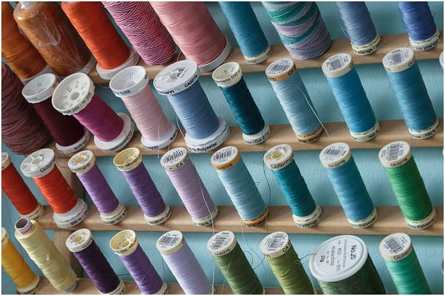 Wall Mounted Rack With Various Coloured Quilting Threads On Bobbins 