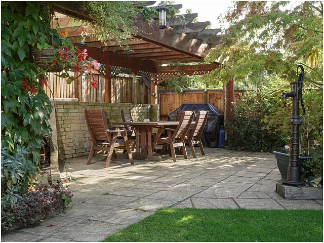 Wide View Wooden Garden Furniture Table Chairs Dappled Shade Paving Pergola Foliage 