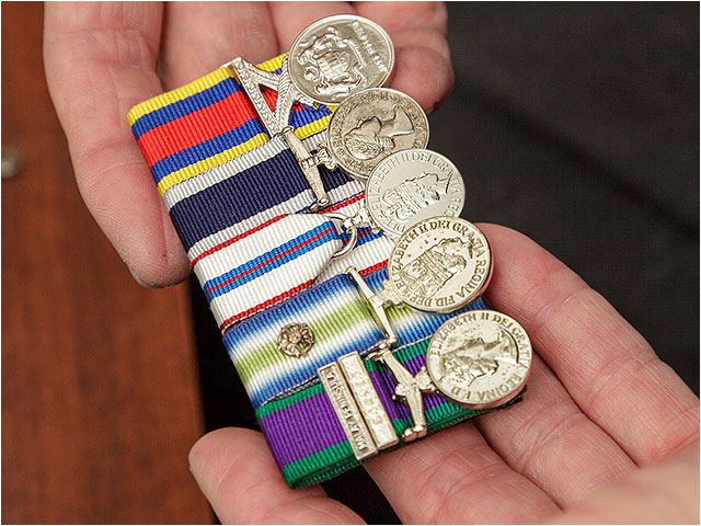 A selection of mounted medals held in the hand