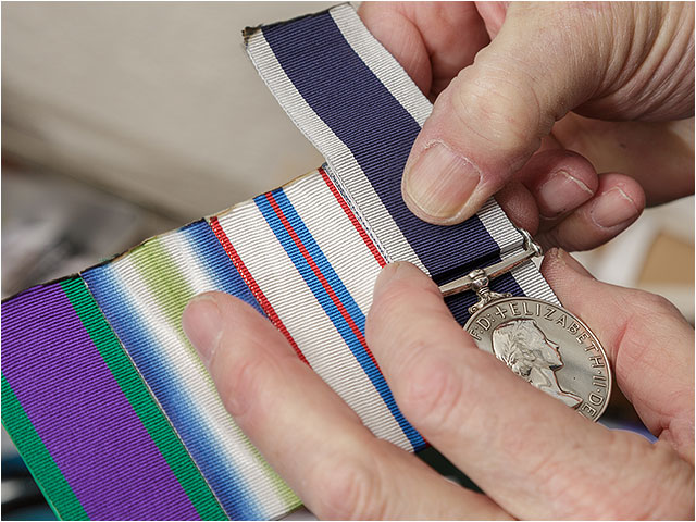 Medal mounter estimating the required length of a ribbon