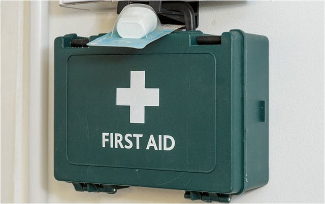 Green first aid box hanging on a wall in the Havant Men’s Shed 