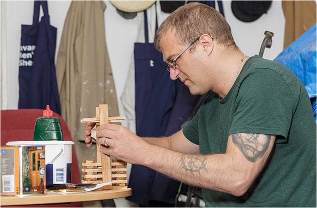 Stasys Balaisis assembling a wooden birdhouse