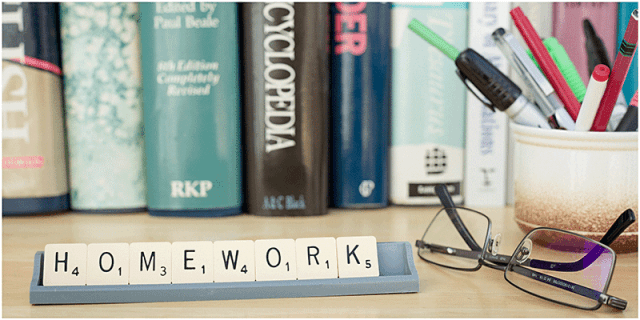 homework scrabble tiles with background of books 