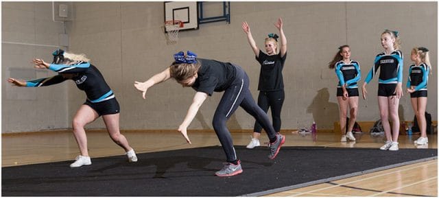 Cheerleaders practicising tumbles and flips 