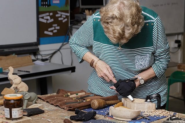 female woodcarver carving a wooden bowl 