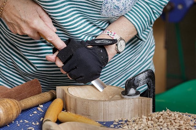 female member of the solent woodcarvers and sculptors guild carving during a carve-in day at portsmouth grammar school 