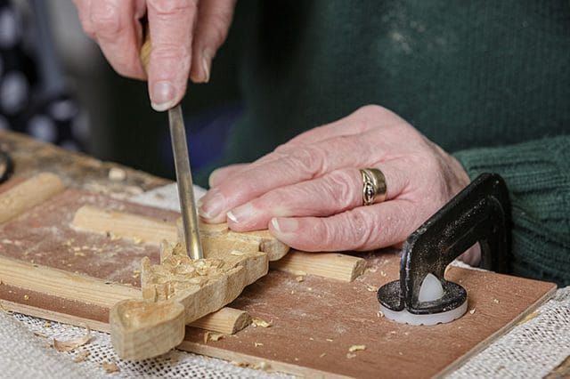 close up of female woodcarvers hands and personal project 