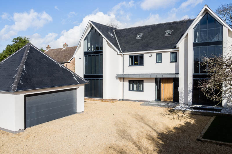 Elevated view of a bespoke self build house with white facing and slate roof