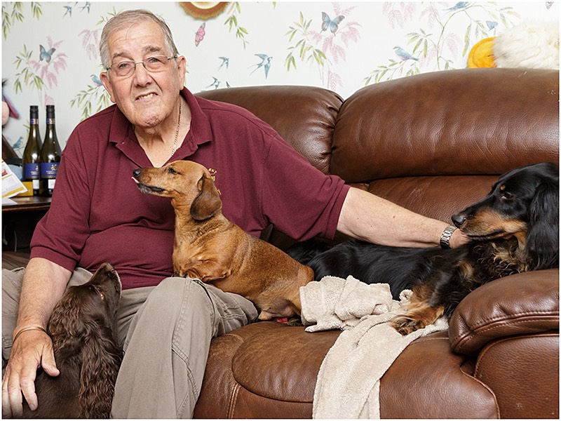 Meccano enthusiast seated with pet dogs on sofa