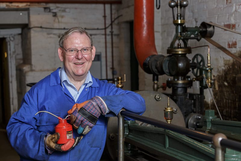 portrait of volunteer steam engineer with engine at bursledon brickworks museum