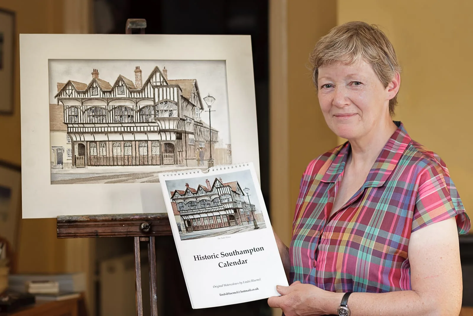 social media marketing portrait of local female historical building watercolour artist holding calendar promoting her work
