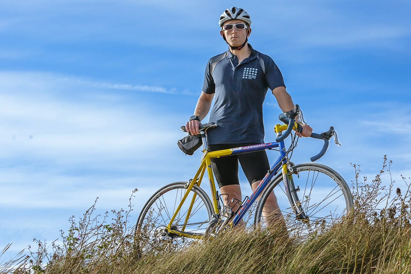 social media portrait of male triathlon competitor standing with competition bicycle