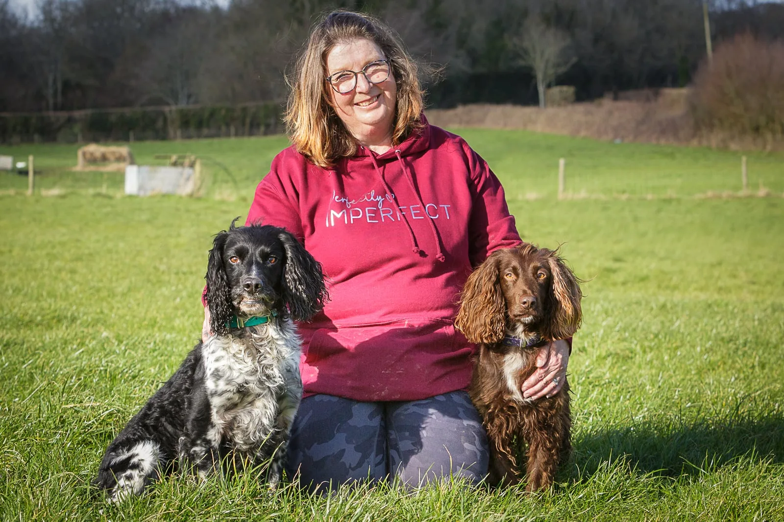 portrait of the female middle-aged owner of a canine behaviour training business with her two dogs