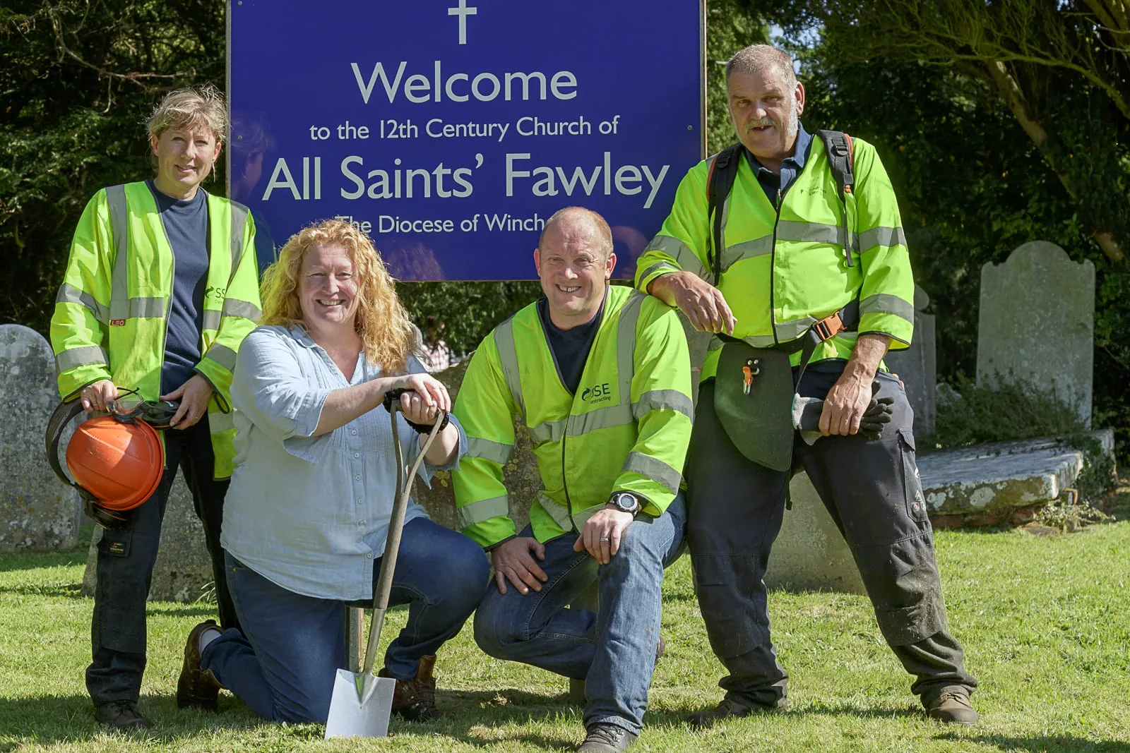 promotional portrait of local council workers and television celebrity undertaking charitable groundworks