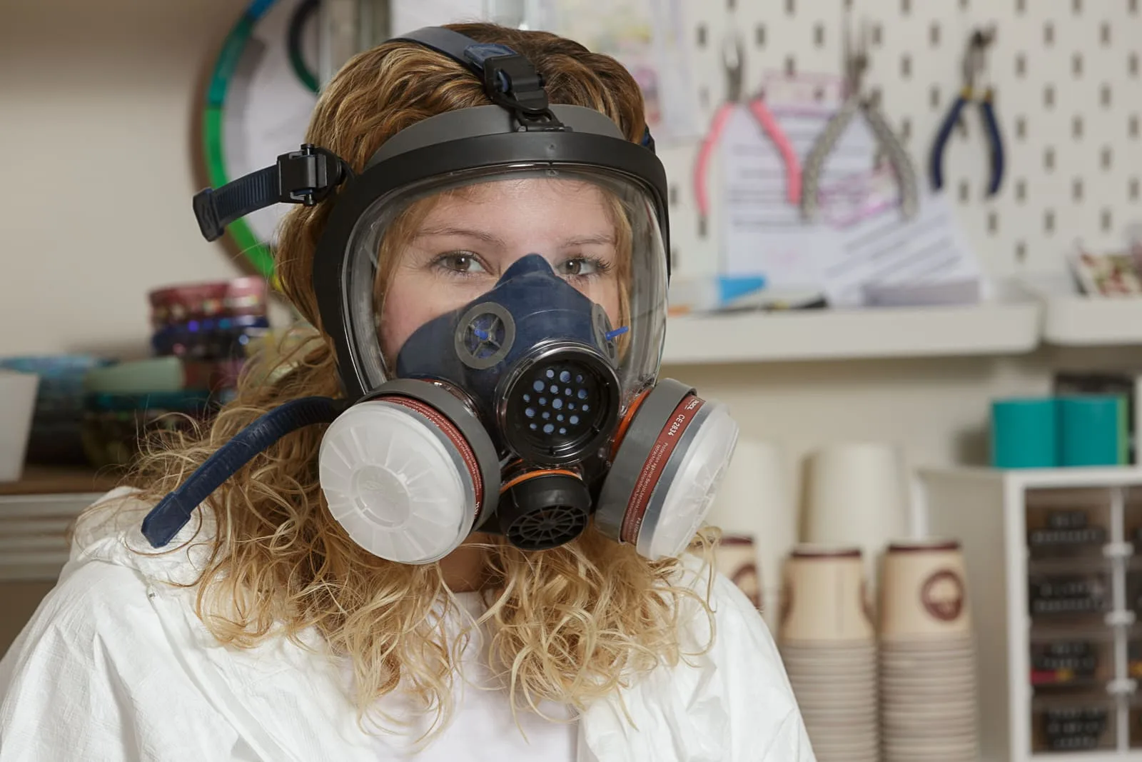 promotional portrait of female owner of cowplain business petal and plum wearing protective clothing and respirator face mask