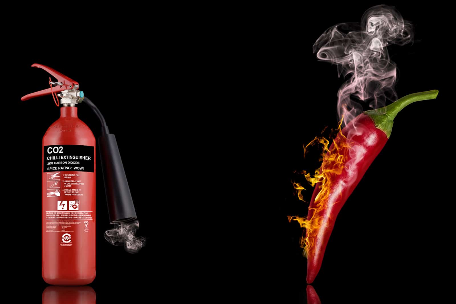 composite photograph of smoking red chillie pepper and red fire extinguisher