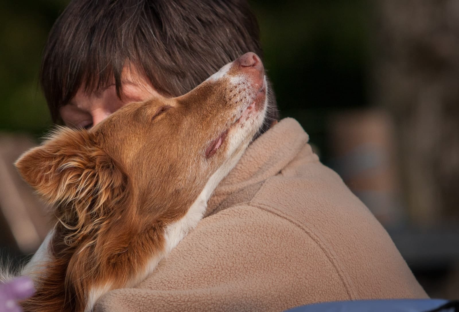 pet owner hugging dog with separation issues