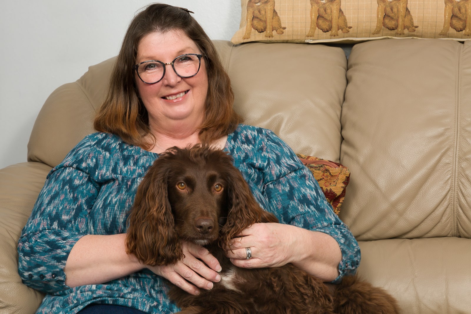 portrait of business owner with chocolate brown cocker spaniel dog on a sofa