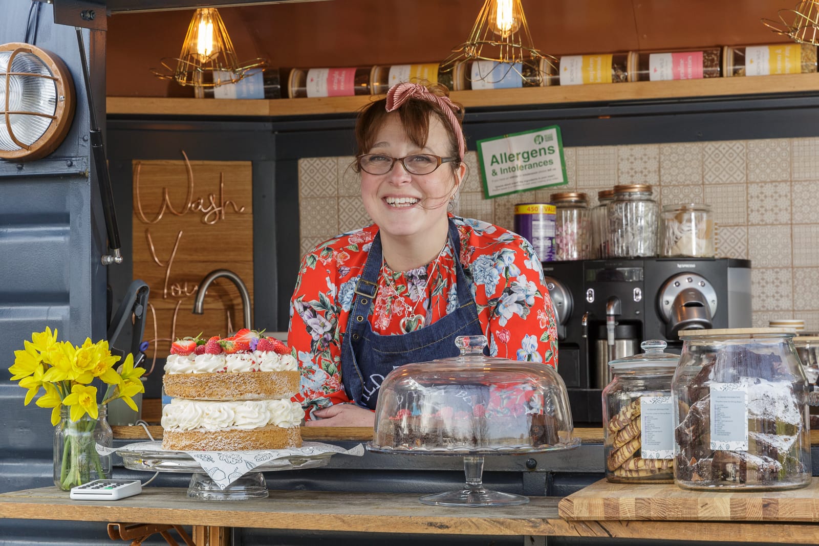 portrait of wild tea bar owner diane at horsebox serving counter with produce