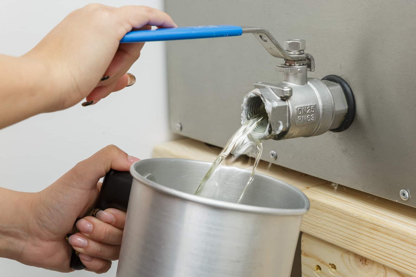 melted wax being collected from wax melting machine in a jug